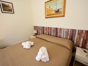 a hotel room with a bed with towels on it at Le Navi in Ortona +3 photos