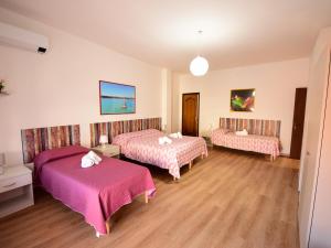 a hotel room with two beds and pink sheets at Le Navi in Ortona