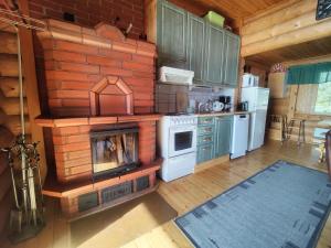 a kitchen with a brick wall with a stove and refrigerator at Kalliorinteen Mökit Havupirtti in Töysä +5 photos