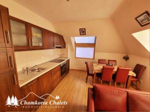 a kitchen with a table and a dining room at Chamkoria Chalets 409 in Borovets
