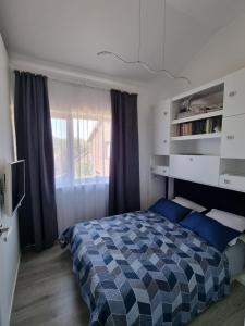 a bedroom with a bed and a window at Vila DRAGONFLY in Šventoji