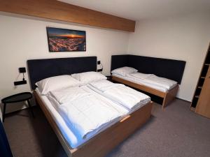 a bedroom with two beds with white sheets at Apartmány Šestka in Staré Město +64 photos