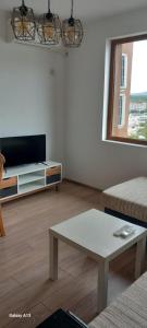 a living room with a tv and a coffee table at Студио Приятели in Tsarevo