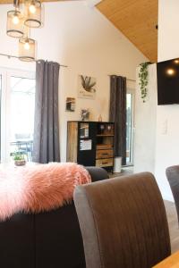 a living room with a couch with an orange furry seat at Ferienhaus Seehuis, Sauna, angeln, familienfreundlich in Twist