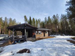 特于塞Kalliorinteen Mökit Lehtipirtti的森林中的小屋,地面上积雪