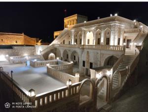 a large building with stairs and lights at night at Hercai Butik Otel in Midyat
