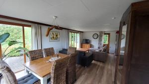 a living room with a wooden table and chairs at Vakantie op de Veluwe in Lunteren