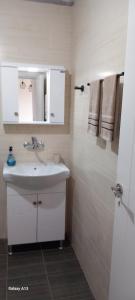 a white bathroom with a sink and a mirror at Студио Приятели in Tsarevo +7 photos