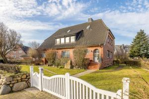 a white fence in front of a house at Appartement Hamburg in Westerland