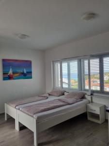 a bedroom with two beds in a room with windows at Matoc apartments in Murter +41 photos