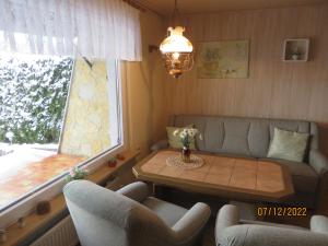 a living room with a couch and a table and a window at Bergblick in Heidersbach +17 photos