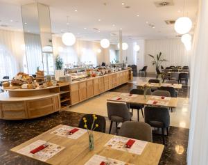 a restaurant with wooden tables and chairs and a cafeteria at Hotel Korkyra in Vela Luka