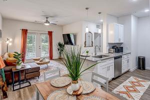 an open kitchen and living room with a table at Boho Bliss w Salt Pool Nr Fern Beach, ARPT, DTWN in Yulee