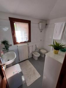 a bathroom with a sink and a toilet and a window at Villa Rosa in Caporciano +20 photos