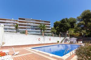 a swimming pool in front of a large building at Verd i Blau - Apartament amb Piscina in Tarragona