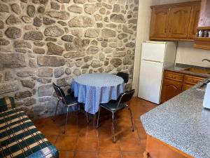 a kitchen with a table and a stone wall at Vale do Gavim, Rua da Estrela in Trancoso