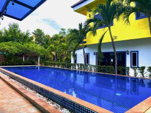 a swimming pool in front of a house with a yellow building at The Secret Garden Hotel in Siem Reap