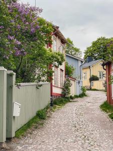 a cobblestone street with houses and a fence at Hotel Onni in Porvoo +42 photos