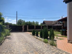 een oprit met een hek en bomen in een tuin bij REDhouse in Baia Mare