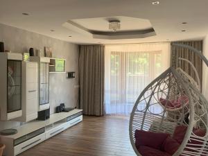 een woonkamer met een hangende stoel en een televisie bij REDhouse in Baia Mare