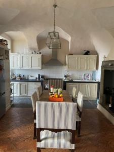 a kitchen with a wooden table with chairs and aendant light at Nobiallum B&B in Menaggio