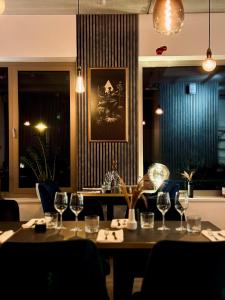 a dining room with a table with wine glasses at Berdorfer Eck - Bed&Breakfast in Berdorf