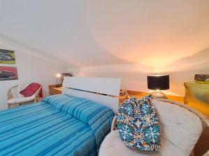 a bedroom with a bed and a couch and a lamp at Magarà Apartment by Casa in mente in Cefalù +26 photos