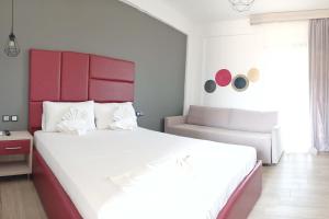 a bedroom with a large white bed with a red headboard at Katerina's Resort in Sarti +22 photos