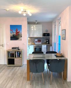 a kitchen and dining room with a table and chairs at Haus Meeresblick Ferienwohnung Kra in Baabe +11 photos
