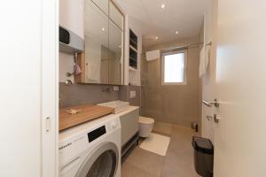 een badkamer met wasmachine en toilet bij Horizont studio in Becici