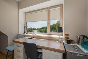 ein Büro mit Schreibtisch und Fenster in der Unterkunft William Willa in Otepää