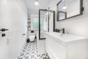 Un baño blanco con lavabo e inodoro. en FeWo Phönixhütte am Baldeneysee in Kupferdreh, en Essen 23 fotos más