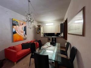 a living room with a glass table and a red couch at Residenza Grimerio in CastellʼArquato