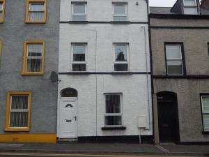 un edificio blanco con puerta y ventanas en Abercorn House, en Derry Londonderry