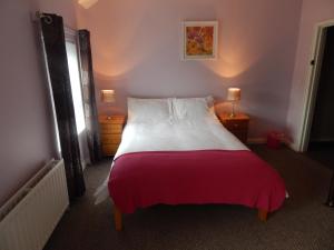 a bedroom with a large bed with a pink blanket at Abercorn House in Derry Londonderry