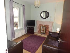 a living room with a couch and a fireplace at Abercorn House in Derry Londonderry