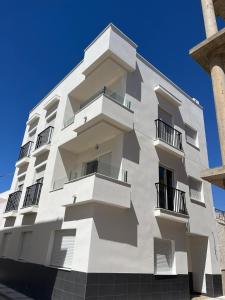 a white building with balconies on the side of it at Apartamento San Antonio in Carboneras +11 photos