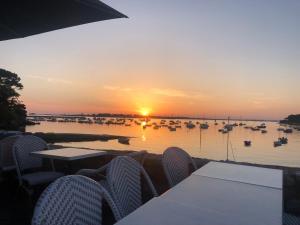 a sunset over a harbor with boats in the water at Appartement idéalement situé in Arzon