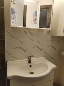 łazienka z białą umywalką i lustrem w obiekcie Apartments Tara and Karla w Novalji +7 zdjęć