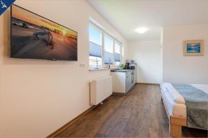 a bedroom with a bed and a tv on a wall at Kimpi 1 in Ostseebad Koserow