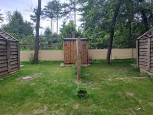 two wooden gates in a yard with a fence at Forest Lodge in Rečica ob Savinji