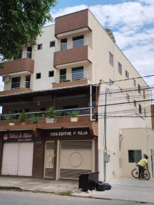 a man riding a bike in front of a building at Apto próx hospital Samaritano in Governador Valadares