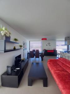 Una sala de estar con un sofá rojo y una mesa. en Silver Coast Heights K, en Lourinhã