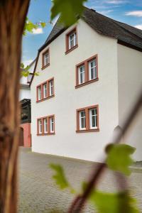 een wit gebouw met bruine ramen bij Winzerhaus am Kardinalsberg in Bernkastel-Kues