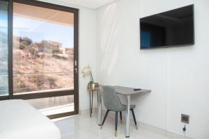 a bedroom with a bed and a table and a window at Guest House Auasblick by State House in Windhoek