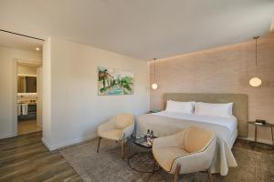 a hotel room with a bed and two chairs at Sant Jaume Design Hotel in Palma de Mallorca