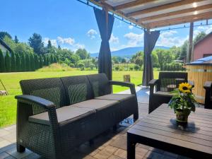 a patio with two chairs and a table with a view at Apartament BESKIDLOVE in Węgierska Górka