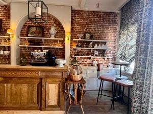 a kitchen with a brick wall and a table and chairs at Maison Mouche in Beaumont-en-Auge