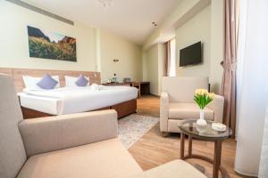 una camera d'albergo con un letto e un tavolo di Kyriad Muscat a Mascate