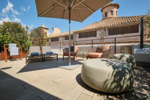a patio with chairs and a table and an umbrella at Sant Jaume Design Hotel in Palma de Mallorca